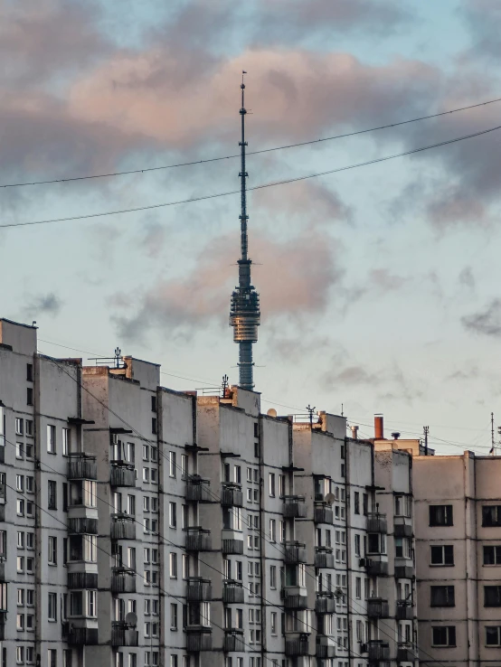 a very tall building with a clock tower in the background, by Adam Marczyński, pexels contest winner, socialist realism, neighborhood, lead - covered spire, фото девушка курит, alessio albi