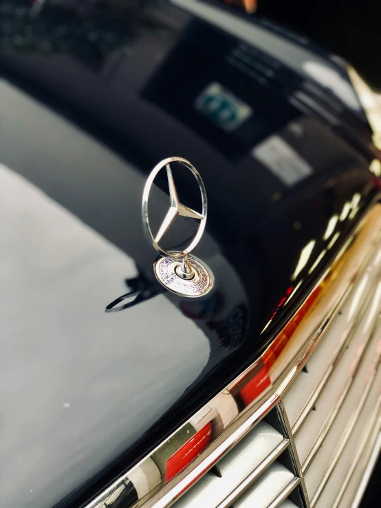 a mercedes emblem on the hood of a car, by Gavin Hamilton, pexels contest winner, taken on iphone 14 pro, profile image, low detailed, celebration