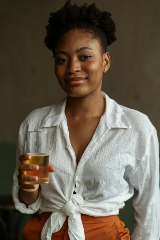 a woman in a white shirt holding a glass of wine, pexels contest winner, renaissance, brown skinned, green tea, wearing a linen shirt, mead