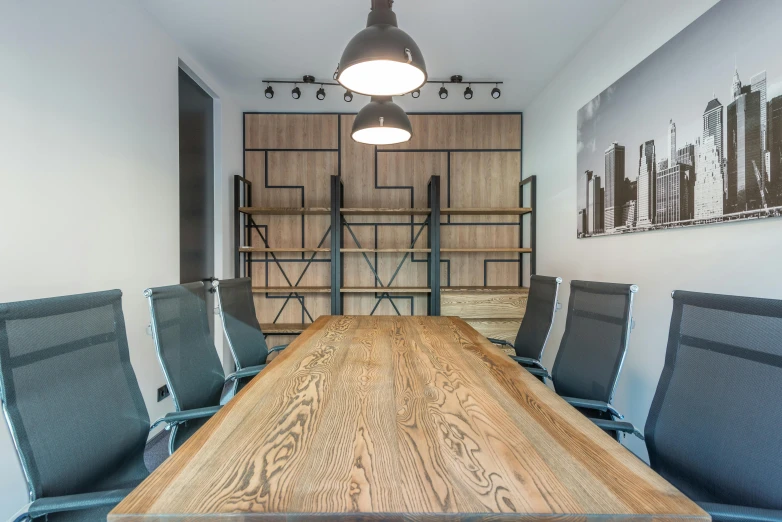 a conference room with a wooden table and blue chairs, by Adam Marczyński, 9 9 designs, industrial space, thumbnail, studio photo