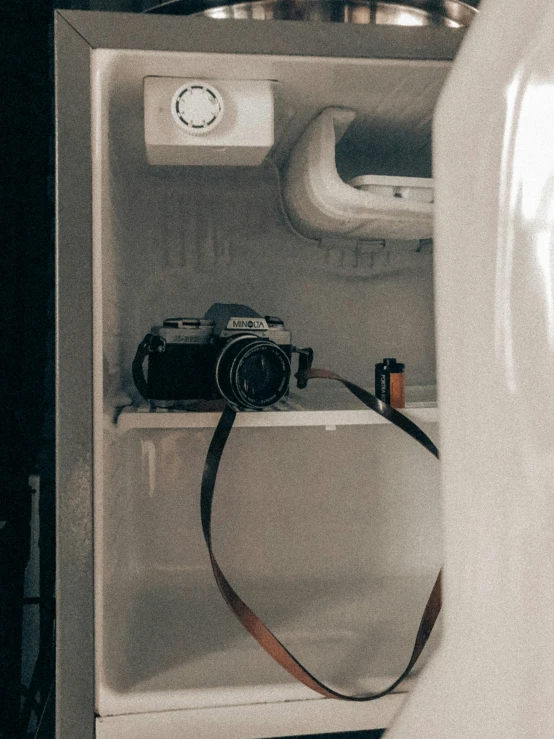 an open refrigerator with a camera in it, inspired by Elsa Bleda, unsplash contest winner, vsco film grain, old photo camera, high quality photo, tourist photo