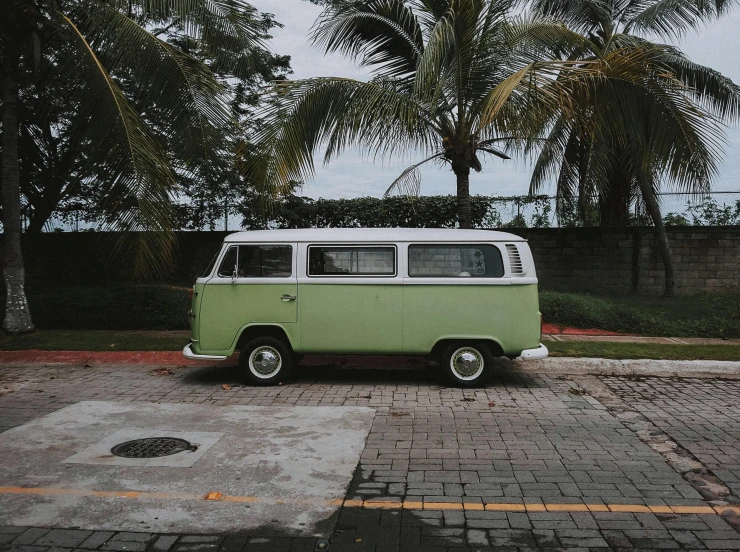 a green and white van parked in a parking lot, a colorized photo, pexels contest winner, 🚿🗝📝