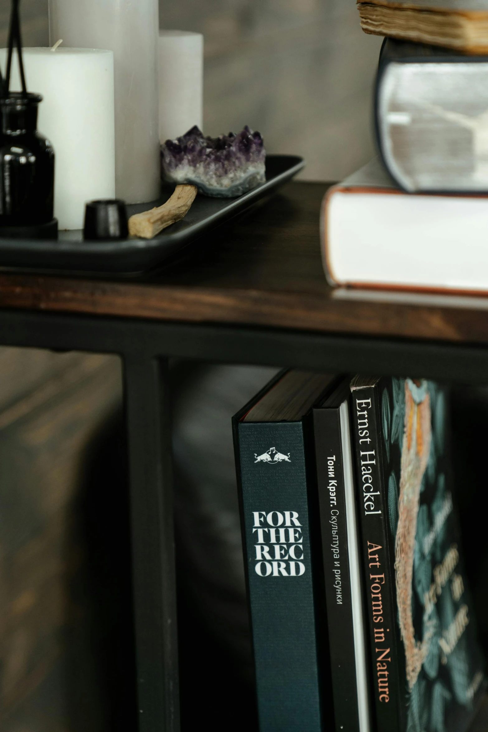 a stack of books sitting on top of a wooden table, obsidian accents, on the altar, detailed product image, shelf