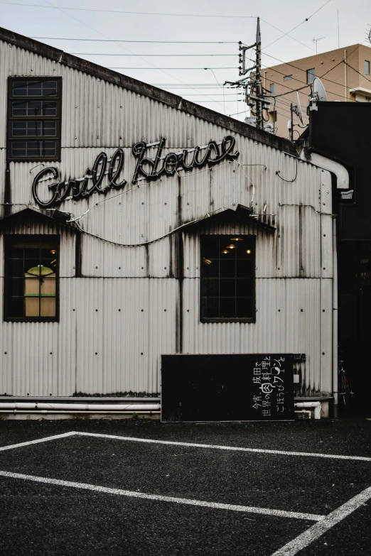 a white building sitting in the middle of a parking lot, pexels contest winner, graffiti, grill, vintage soft grainy, dimly lit cozy tavern, thumbnail