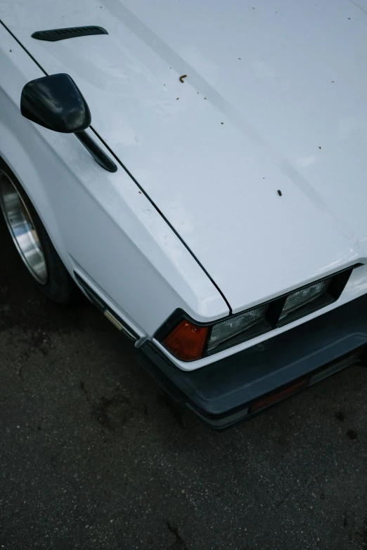 a white car parked in a parking lot, ae 8 6, low quality photo, close up details, taken with sony alpha 9