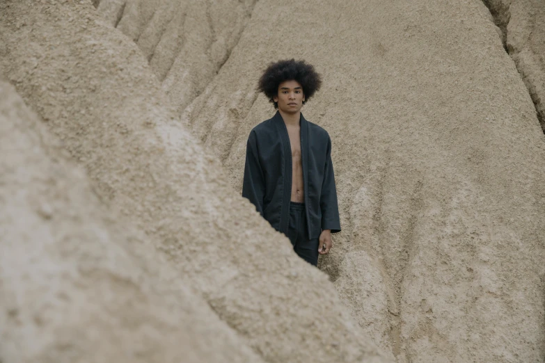 a man standing in the middle of a desert, an album cover, unsplash, samurai with afro, wearing black silk robes, photo of a model, ignant