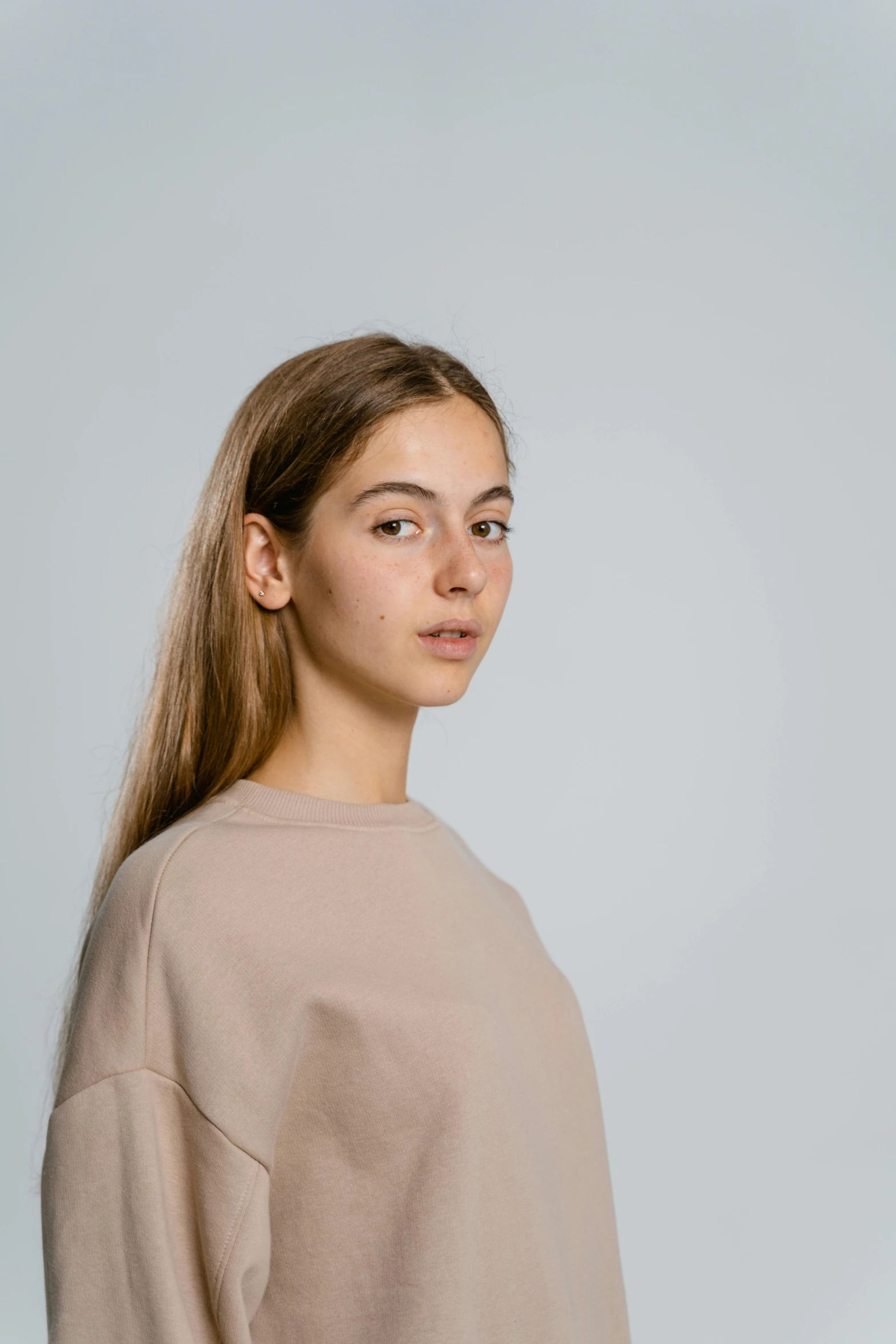 a woman standing in front of a white background, a character portrait, trending on unsplash, realism, brown sweater, 1 6 years old, product introduction photo, nft portrait