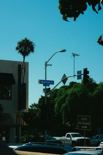 a street filled with lots of traffic next to tall buildings, unsplash, the city of santa barbara, street signs, low quality photo, streetlamp