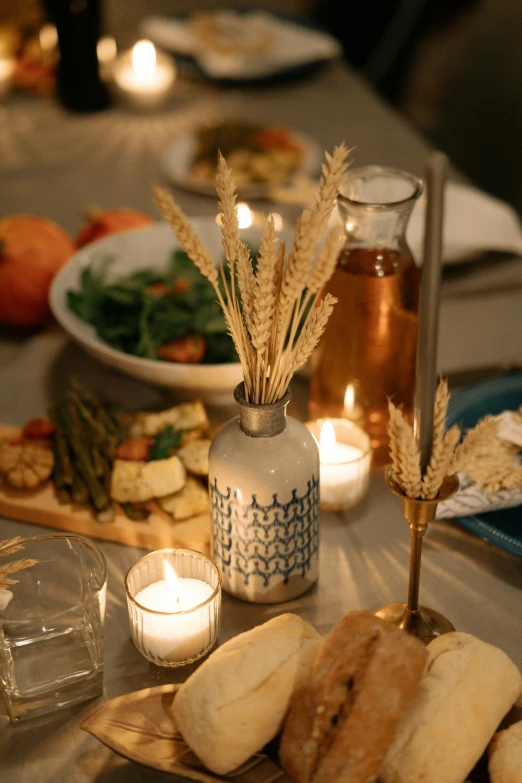 a table topped with plates of food and candles, unsplash, stems, close up angle, hay, tabletop model