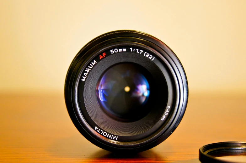 a camera lens sitting on top of a wooden table, a macro photograph, by Mathias Kollros, medium format