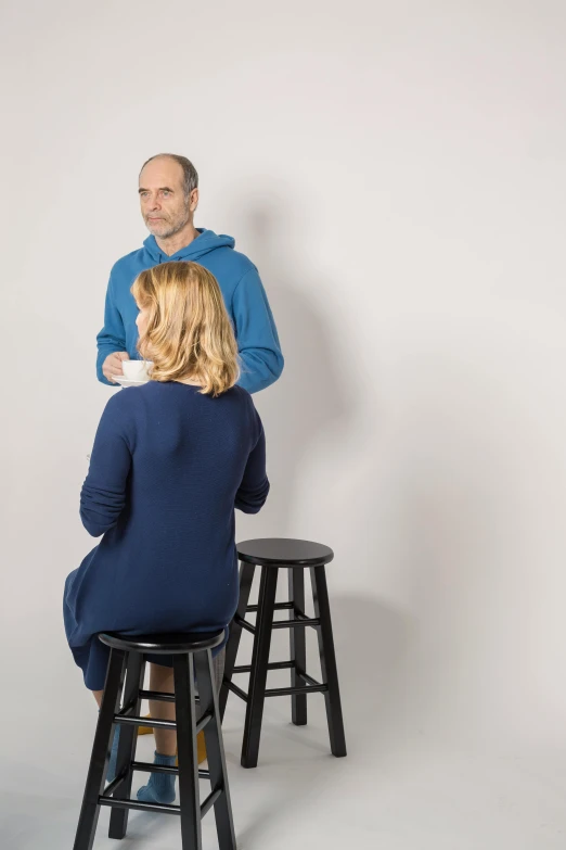 a man and a woman sitting on stools, lynn skordal, high res photograph, comforting, profile image