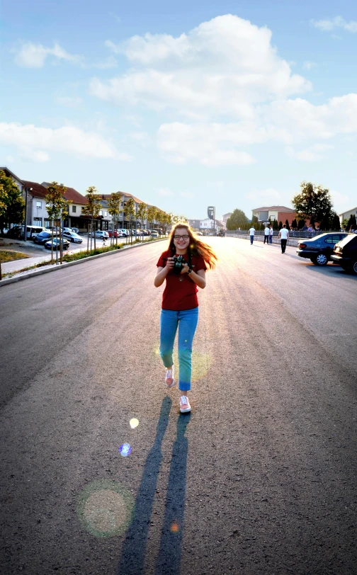 a woman walking down a street holding a cell phone, by Sven Erixson, pexels contest winner, happening, panoramic centered view of girl, in a suburb, the sun shines in, running towards camera