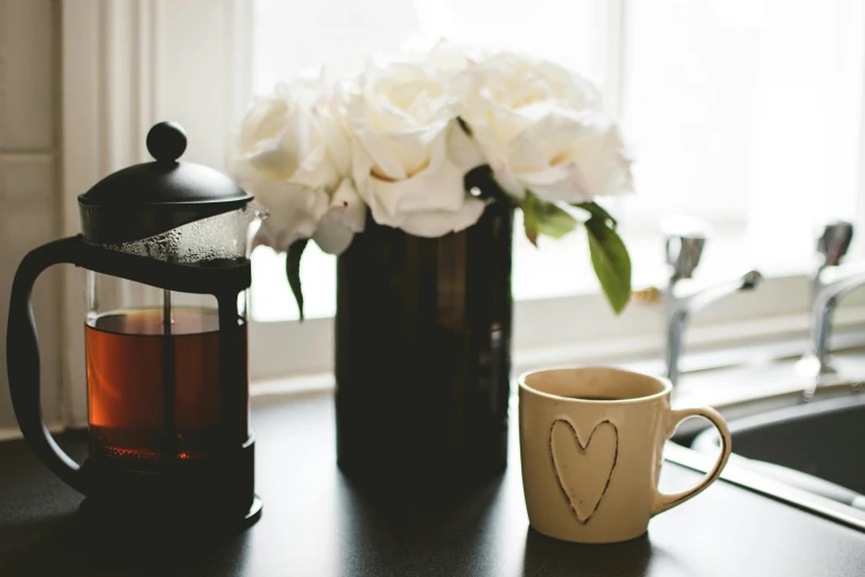 a coffee pot sitting on top of a kitchen counter next to a cup, unsplash, romanticism, black peonies, close-up photograph, high resolution, beatifully lit