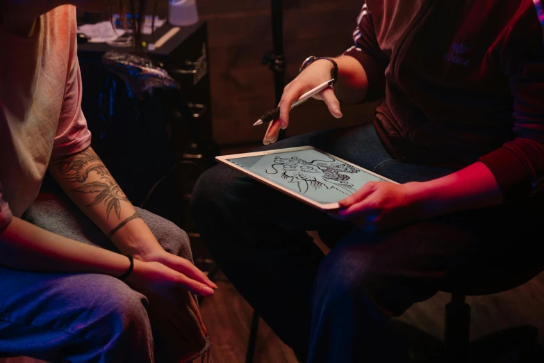 a couple of people that are sitting down with a tablet, a tattoo, by Meredith Dillman, trending on pexels, interactive art, a seance, performing, medium close up shot, professional drawing