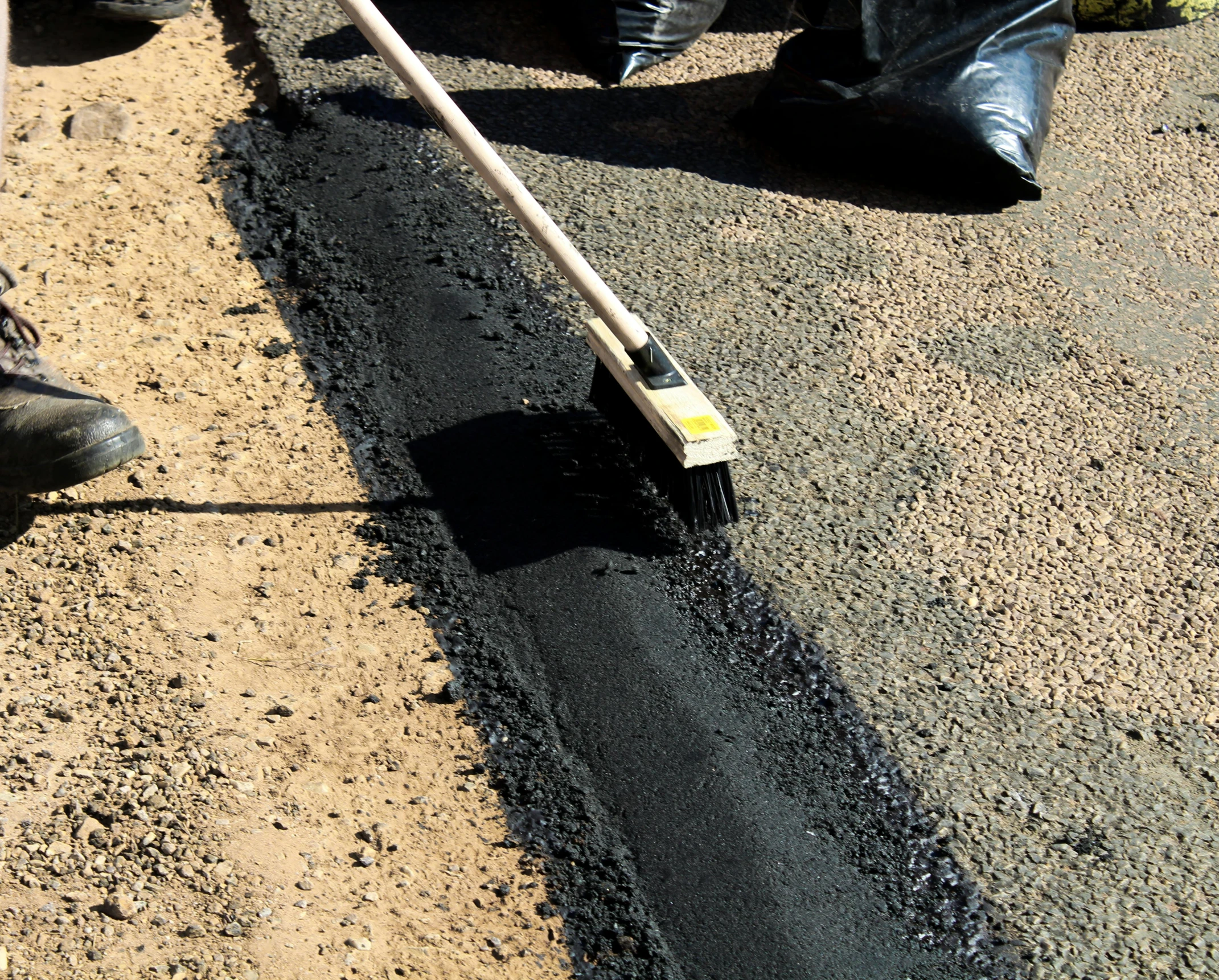 a person laying asphalt on the side of a road, plasticien, black main color, easy to use, thick lining, brush work