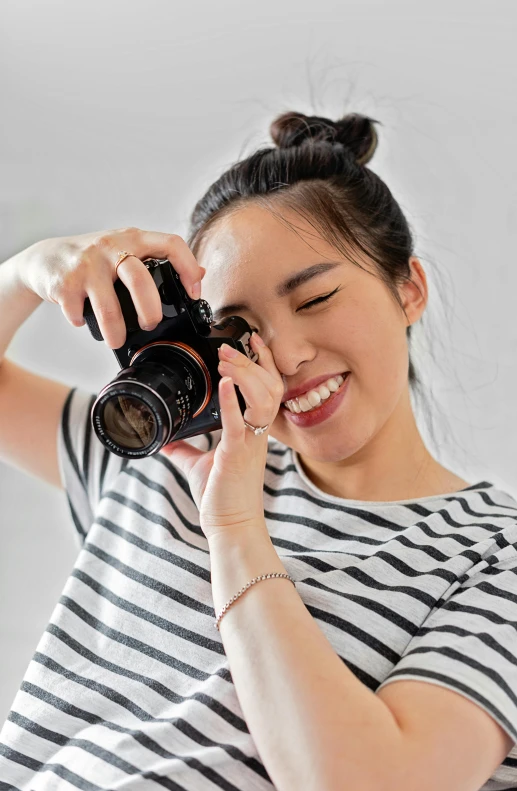 a woman taking a picture with a camera, a picture, pexels contest winner, winking at the camera, young asian woman, ad image, professional profile picture