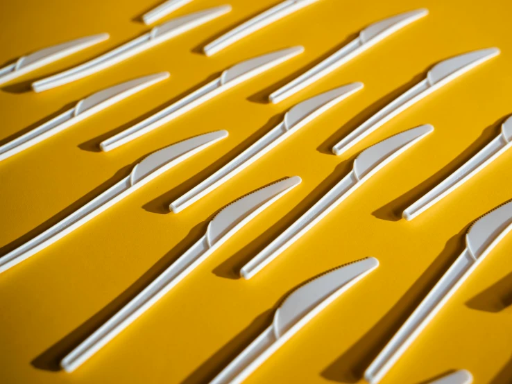 a bunch of forks sitting on top of a table, inspired by Lucio Fontana, unsplash, op art, white and yellow scheme, detail render, fused aircraft parts, behance lemanoosh