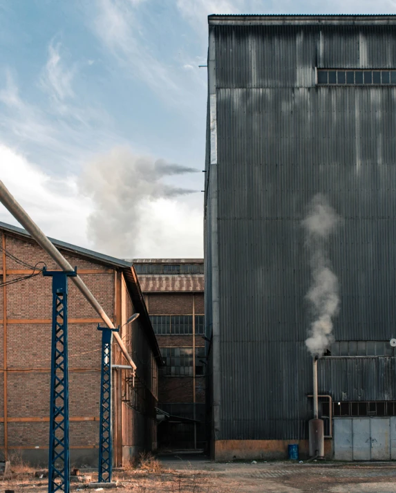 a building with a lot of smoke coming out of it, by Tobias Stimmer, mill, iron cladding, thumbnail, sustainability