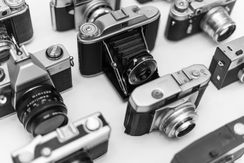 a group of cameras sitting on top of a table, a black and white photo, medium format, stacked image, ecommerce photograph, camera photo