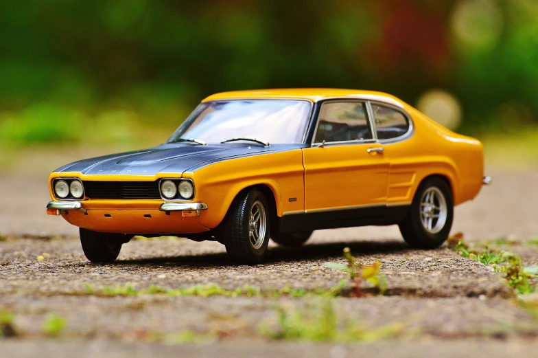 a toy car is sitting on the ground, inspired by Harry Haenigsen, pexels contest winner, muscle cars, scimitar, avatar image, mustard