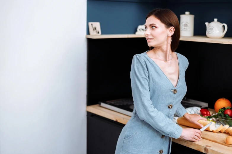 a woman standing in a kitchen preparing food, by Emma Andijewska, pexels contest winner, female in office dress, denim, background image, handsome girl