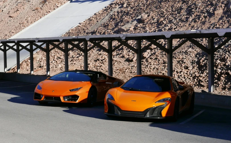 two orange sports cars parked next to each other, square, las vegas, peak experience ”, premium