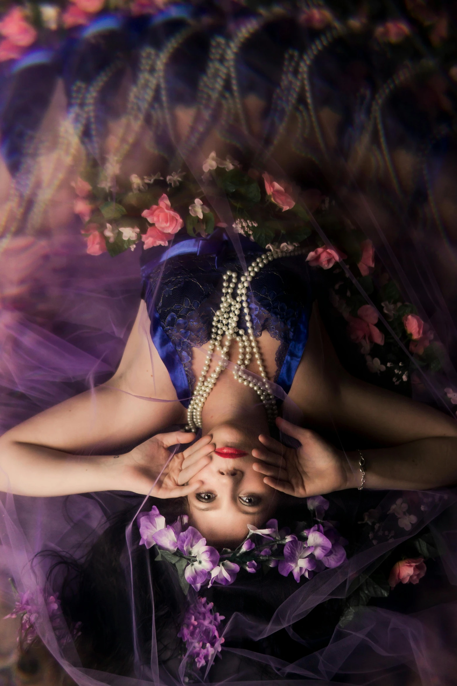 a woman in a purple dress laying on a bed, a portrait, inspired by Brooke Shaden, unsplash, japanese shibari with flowers, pearls and chains, shot from below, playful pose of a dancer