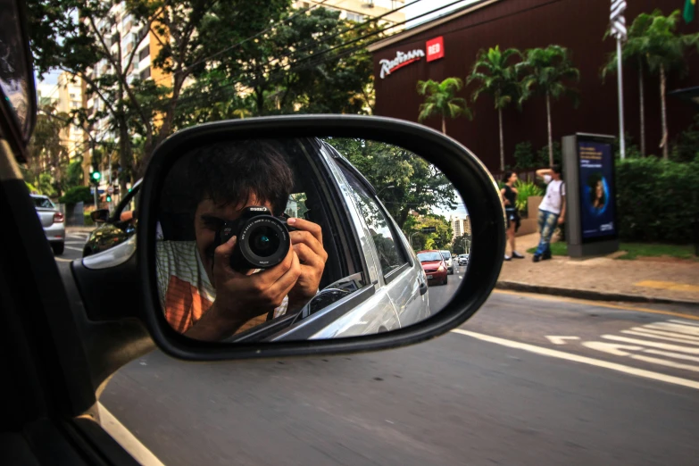 a man taking a picture of himself in the rear view mirror of a car, a picture, pexels contest winner, photorealism, south jakarta, in sao paulo, taken in the late 2010s, paparazzi shot