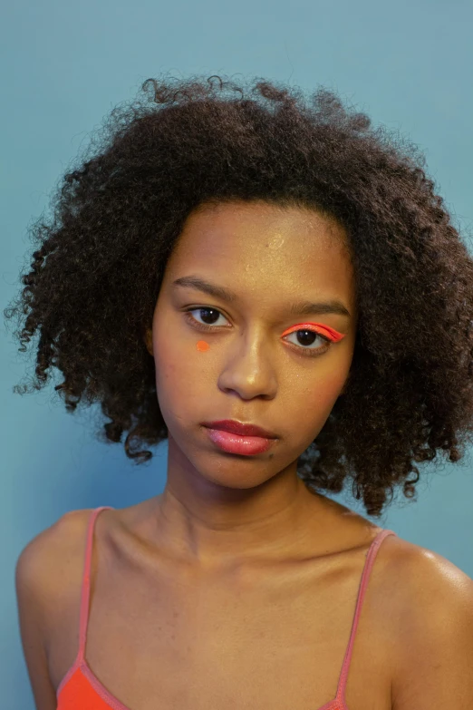 a close up of a person with an afro, by Lily Delissa Joseph, trending on pexels, photorealism, red neon eyes, portrait sophie mudd, pink and orange, non binary model