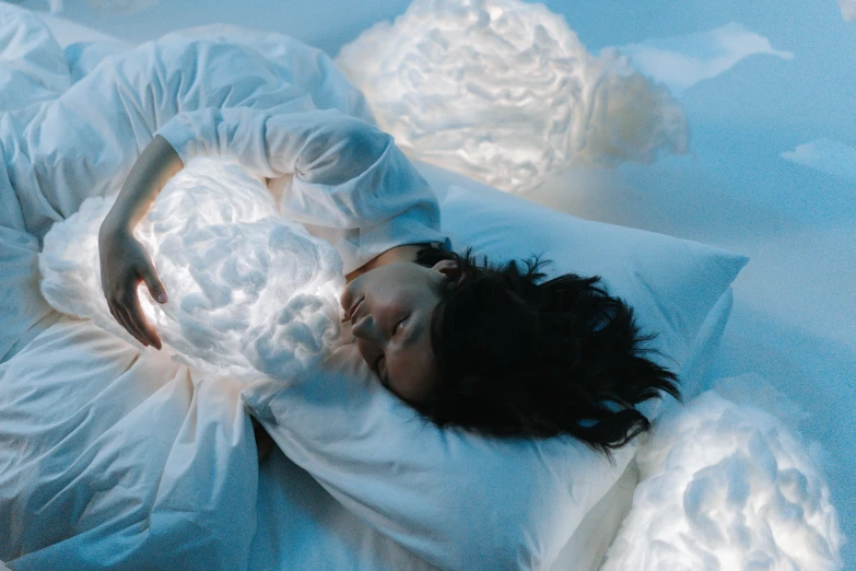 a woman laying on top of a bed covered in white sheets, a hologram, inspired by Elsa Bleda, pexels contest winner, emitting spore clouds, emerging from her lamp, gemma chen, trending in artsation