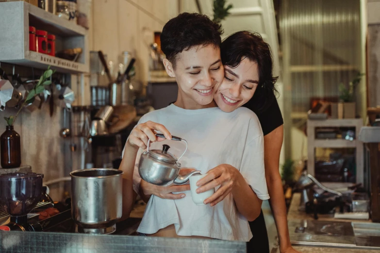 a couple of women standing next to each other in a kitchen, pexels contest winner, happening, aussie baristas, lesbian embrace, pouring, male and female