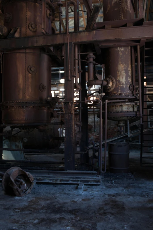 a man riding a skateboard on top of a cement floor, unsplash, renaissance, chemical plant, with vestiges of rusty machinery, 9 steel barrels in a graveyard, cavernous interior wide shot