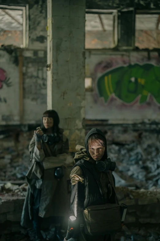 a couple of people sitting on top of a pile of rubble, unsplash contest winner, graffiti, frame from prometheus movie, wearing apocalyptic clothes, war boys, in an abandoned warehouse