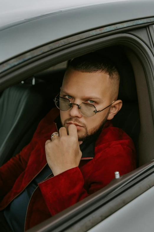 a man sitting in the passenger seat of a car, an album cover, inspired by Károly Brocky, professional modeling, red car, beskinski, millennial vibes