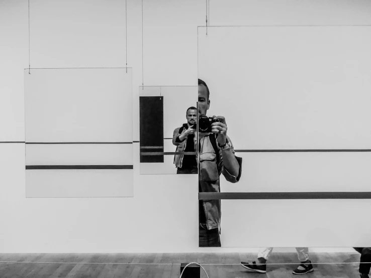 a man taking a picture of himself in a mirror, a black and white photo, inspired by Arnold Newman, unsplash, minimalism, 4k museum photograph, abstract mirrors, museum photo, saatchi art