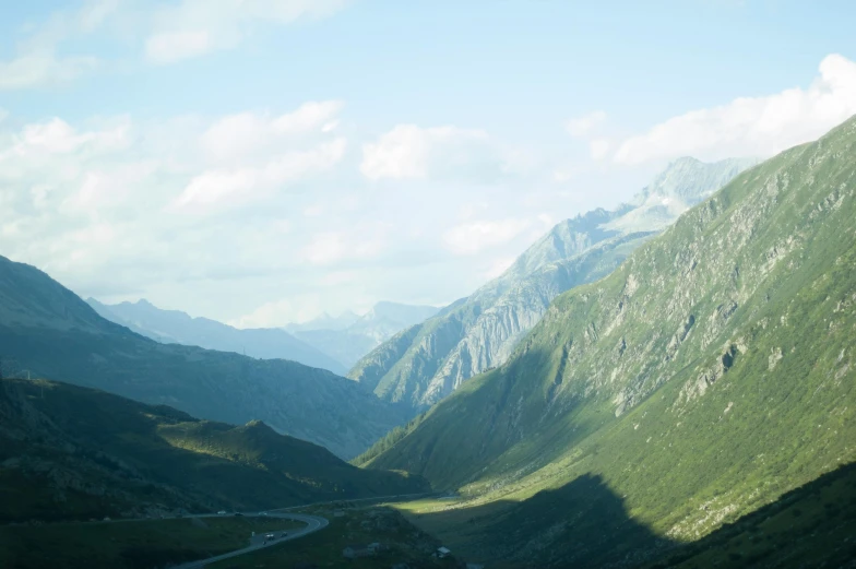 a view of a valley with mountains in the background, by Werner Andermatt, pexels contest winner, les nabis, green, side, guillaume tholly, high light on the left