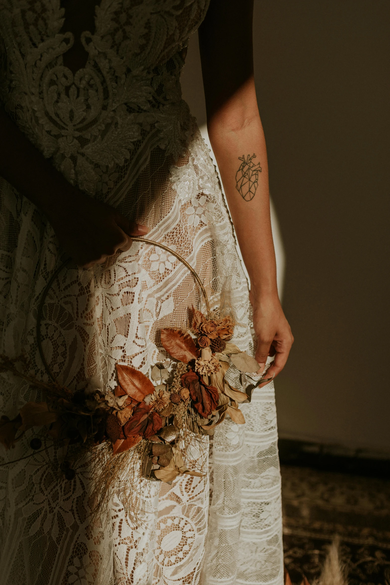 a woman in a wedding dress holding a bouquet, a tattoo, by Jessie Algie, pexels contest winner, symbolism, earthy colours, tattoo sleeve on her right arm, ethereal details, graphic print