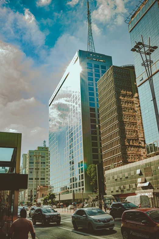 a city street filled with lots of traffic and tall buildings, a screenshot, pexels contest winner, modernism, chile, sunny sky, buildings made out of glass, 35 mm photo