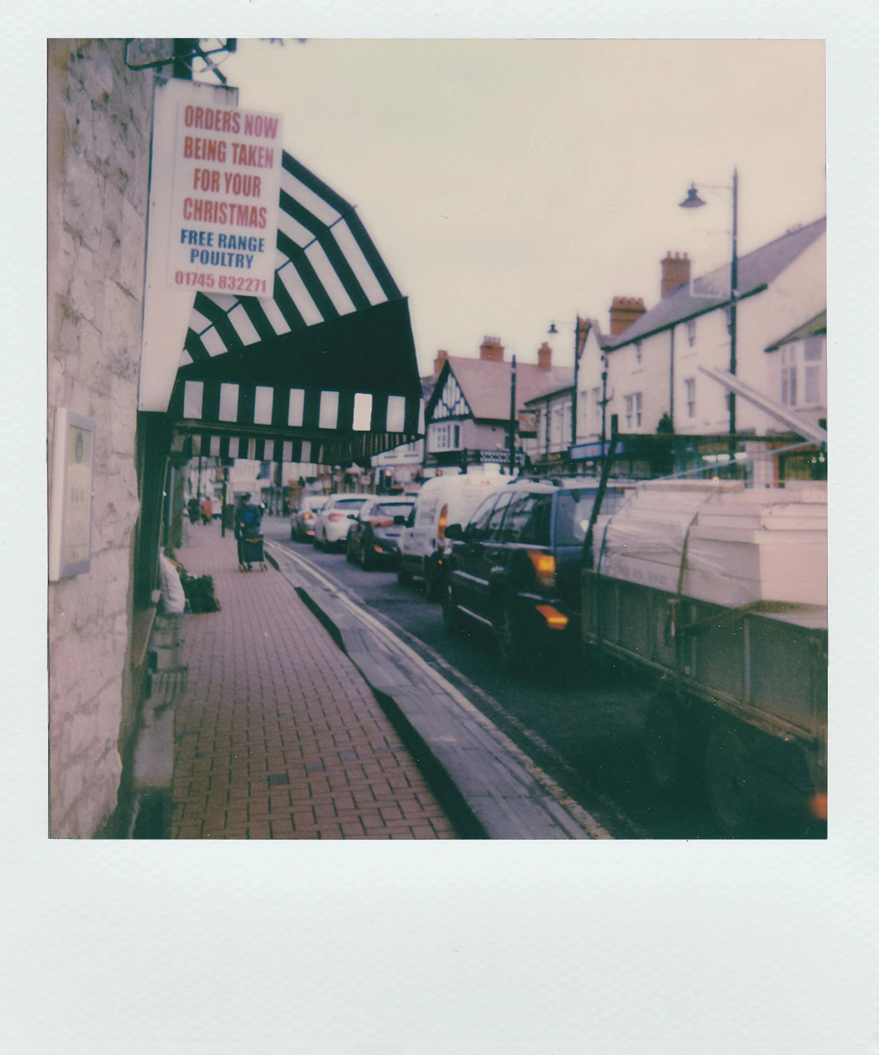 the cars are parked on the side of the road, a polaroid photo, by IAN SPRIGGS, unsplash, private press, coventry city centre, medium format, old town