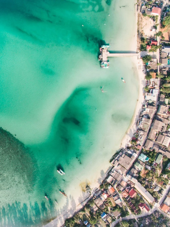 a large body of water next to a beach, a screenshot, pexels contest winner, airborne view, fishing village, visually crisp & clear, thumbnail