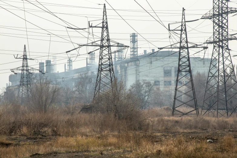 a red fire hydrant sitting in the middle of a field, by Adam Marczyński, shutterstock, lots of hanging cables and wires, power plants with smoke, ukraine. photography, seen from a distance