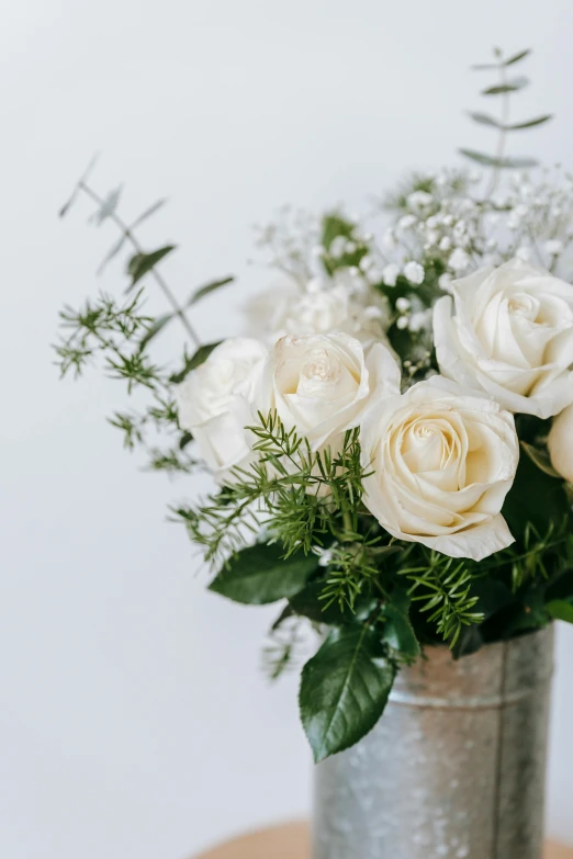 a vase filled with white flowers on top of a wooden table, trending on unsplash, crown of peach roses, silver and muted colors, set against a white background, finely textured