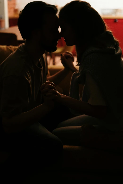a man and a woman sitting on a couch, by Adam Marczyński, pexels, romanticism, reylo kissing, dim lighting, holding each other hands, ( ( theatrical ) )