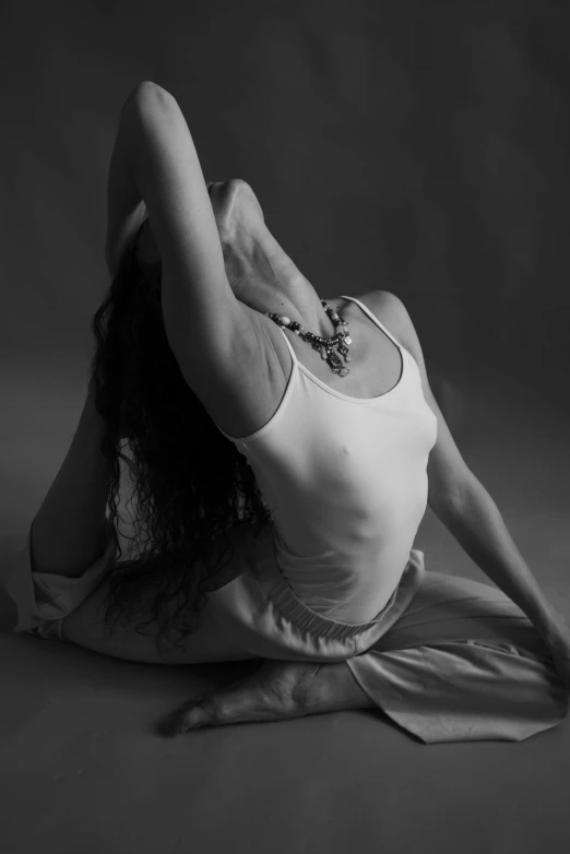 a black and white photo of a woman doing yoga, flickr, arabesque, her hair flowing down, sitting pose, lower back, inner glow