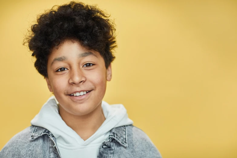 a young boy with curly hair smiling at the camera, trending on pexels, ashcan school, yellow backdrop, black teenage boy, avatar image, on grey background