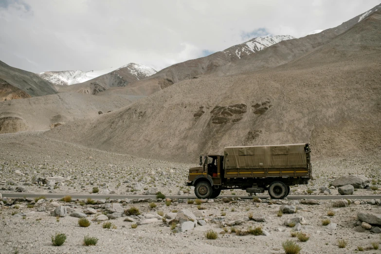 a truck that is sitting in the dirt, by Peter Churcher, hurufiyya, in the midst of high mountains, jaya su berg, an olive skinned, panels