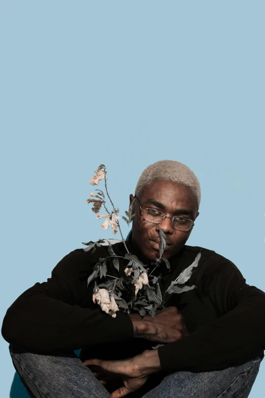 a man sitting on a chair with a flower in his hand, an album cover, inspired by Paul Georges, trending on unsplash, a silver haired mad, playboi carti, humanoids overgrown with flowers, profile image