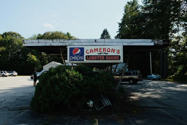 a sign that is on the side of a building, by Carey Morris, unsplash contest winner, photorealism, lobster, abandoned gas station, in the styles of cameron look, family photo