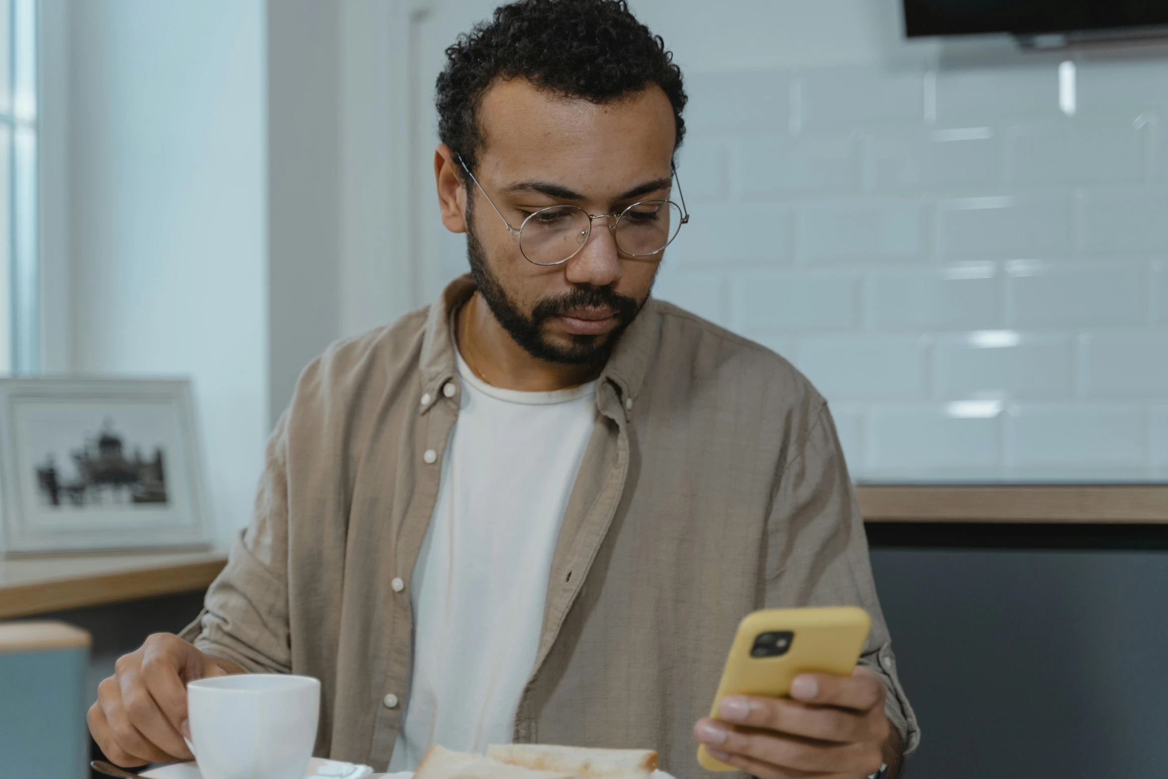 a man sitting at a table using a cell phone, trending on pexels, hyperrealism, with glasses and goatee, an olive skinned, avatar image, reading