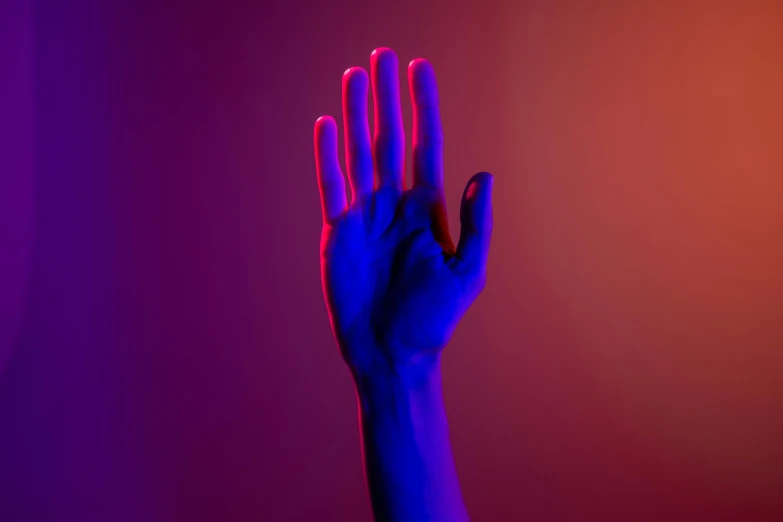 a person holding their hand up in the air, an album cover, inspired by Elsa Bleda, pexels, aestheticism, red and blue neon, purple volumetric lighting, thin blue arteries, contrasting colors